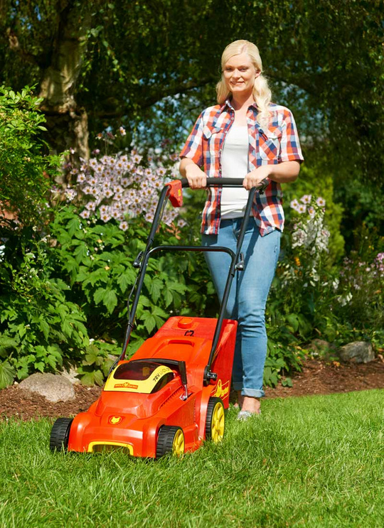 Frau mäht Rasen mit einem Elektromäher von Wolf Garten